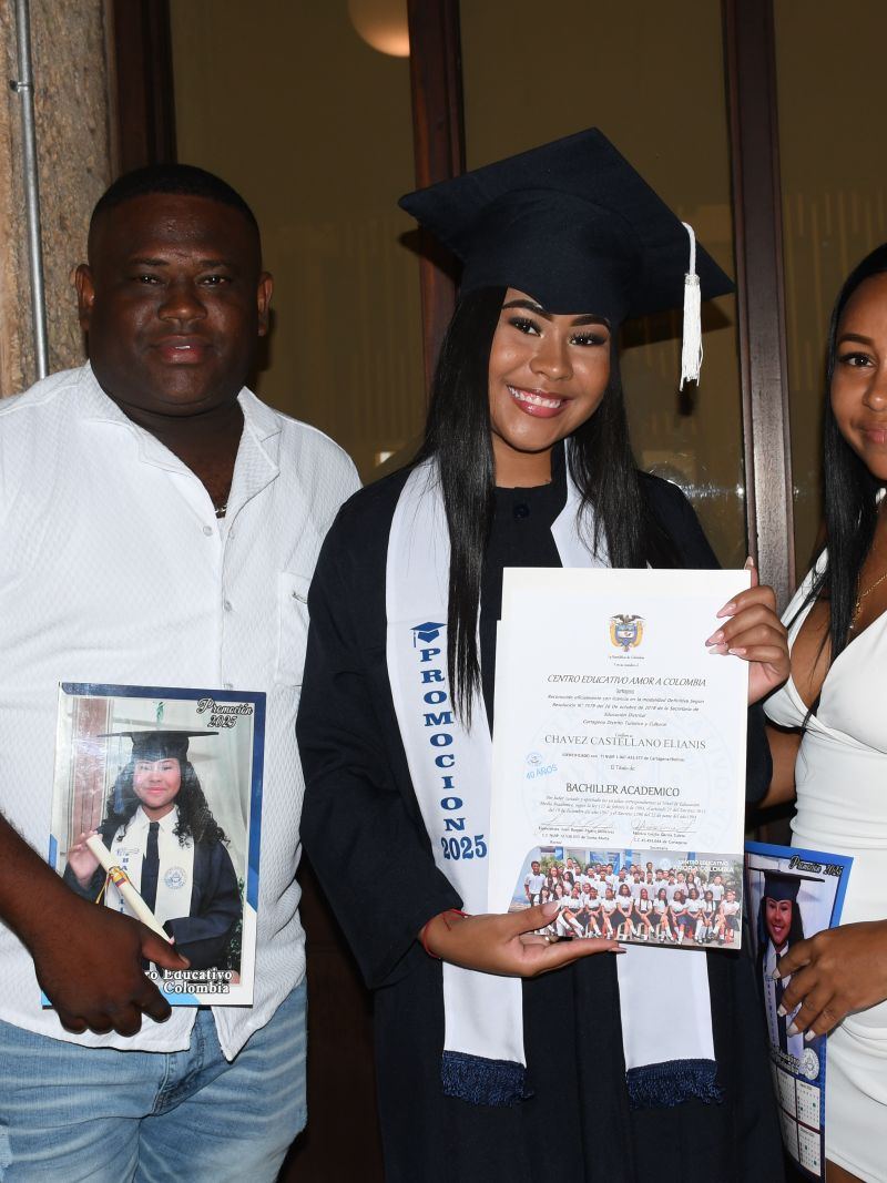 Graduada con su mamá y su papá mostrando el diploma y una foto enmarcada